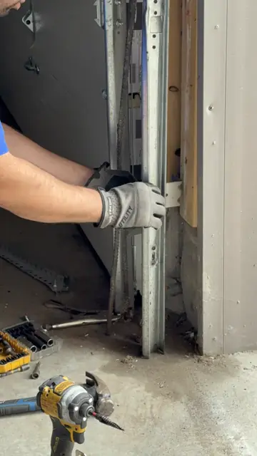 Technician adjusting the garage door track at the opening
